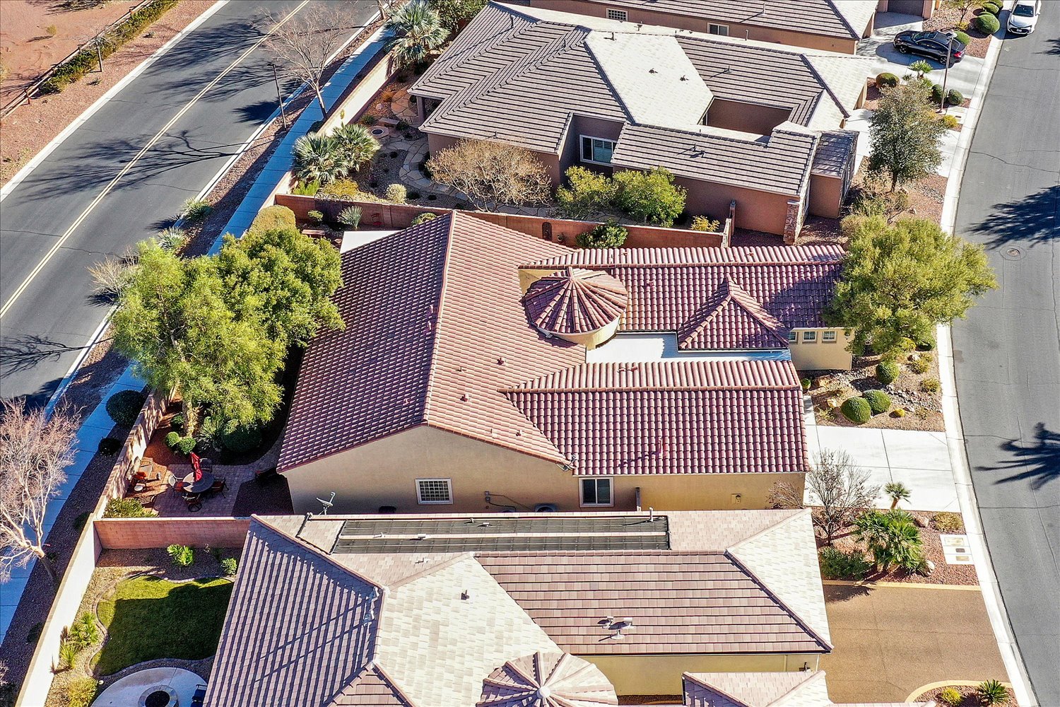 Backyard fire pit with curved bench seating and desert plants