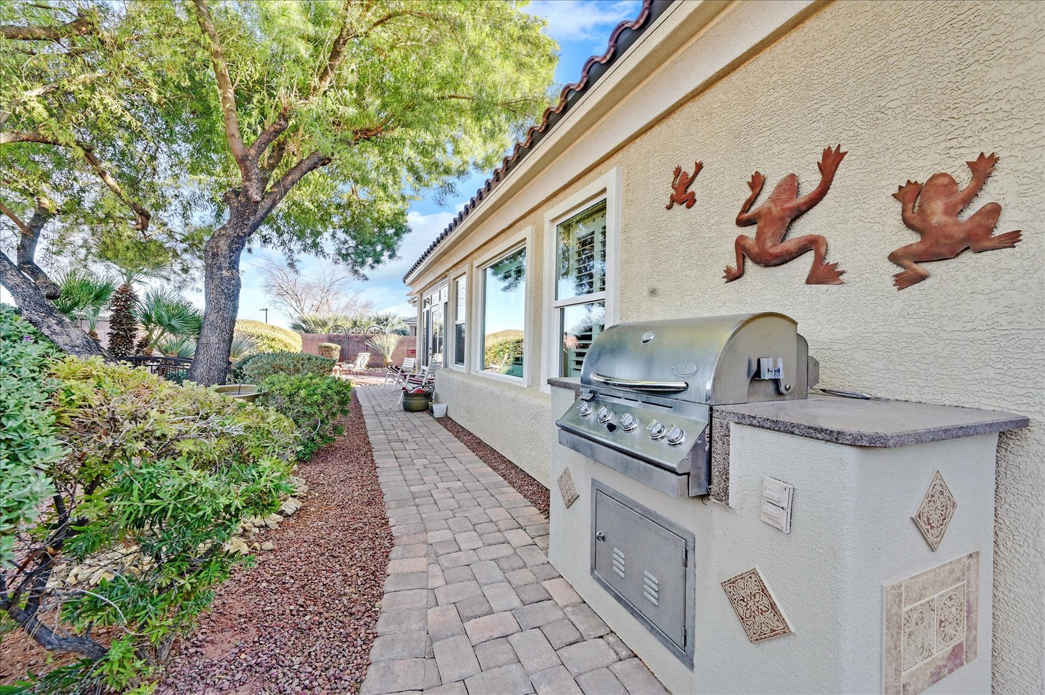 Built-in outdoor kitchen grill along paver walkway